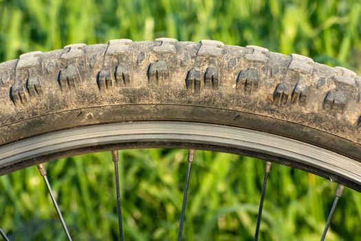 Close up of a dirt bicycle wheel with tire and spokes