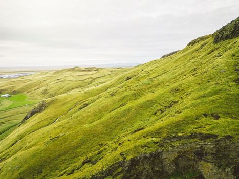 Icelandic landscape with vibrant green hills and countryside grazing sheep, in late afternoon lights in the highlands, Iceland. High quality photo