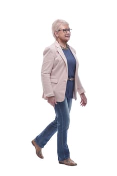 in full growth. confident senior woman goes forward . isolated on a white background