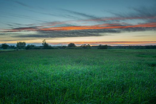 Evening sky over the green meadow, picturesque eastern Poland, summer view