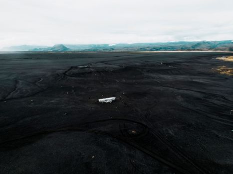 Crashed military plane in black sand Solheimasandur beach. The US Navy DC-3 super bus airplane crash landed in Iceland. Solheimasandur beach, close to town Vik. High quality photo