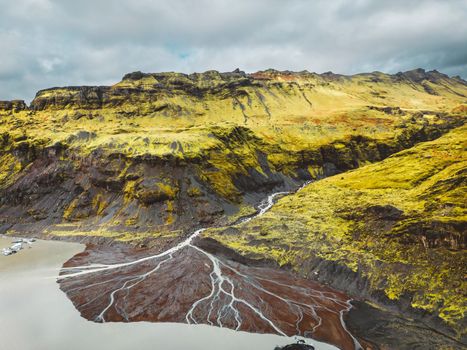 Aerial view of Icelandic riverbed flowing into the sea. River flowing through the volcanic landscape of Iceland. High quality photo