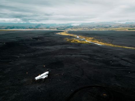 Crashed military plane in black sand Solheimasandur beach. The US Navy DC-3 super bus airplane crash landed in Iceland. Solheimasandur beach, close to town Vik. High quality photo