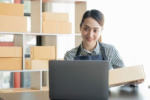 Asian girl working with boxes at home office small business owner start up Entrepreneur, small business, SME or self-employed online and delivery concept.