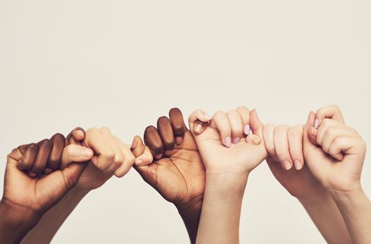 Sticking together. a group of unrecognizable people holding one anothers thumbs in a single line