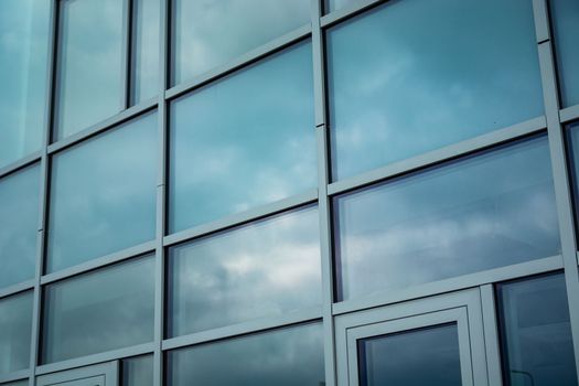 Clouds reflecting in the fragment facade of a modern building