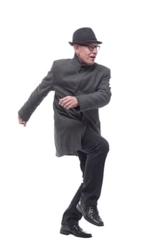 cheerful man in a hat and autumn coat striding forward . isolated on a white background
