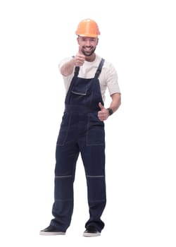 in full growth. smiling man in overalls showing thumbs up . isolated on white background
