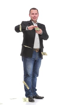 Handsome young man in formalwear throwing money and looking at camera. Consept of rich and successful.