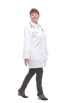 Female doctor walking towards the camera smiling isolated over a white background