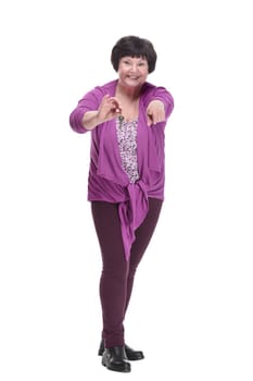 in full growth.happy senior woman with keys in hand. isolated on a white background.