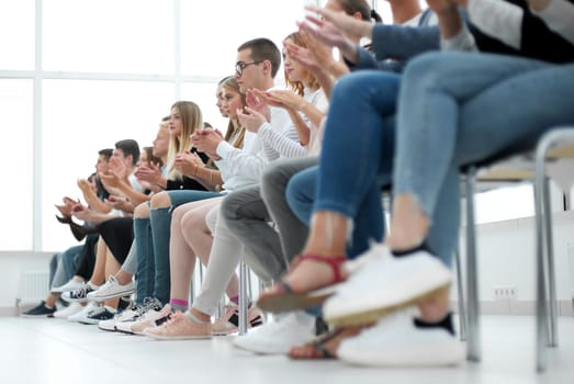 background image of young people applauding in the conference room. photo with copy space