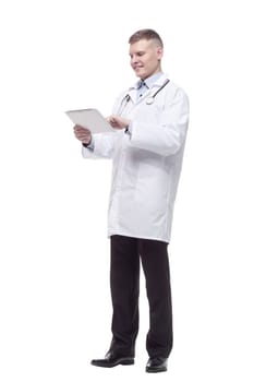 in full growth. young doctor with a digital tablet. isolated on a white background.