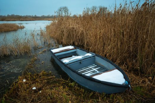 A small boat on the shore of a frozen lake, eastern Poland