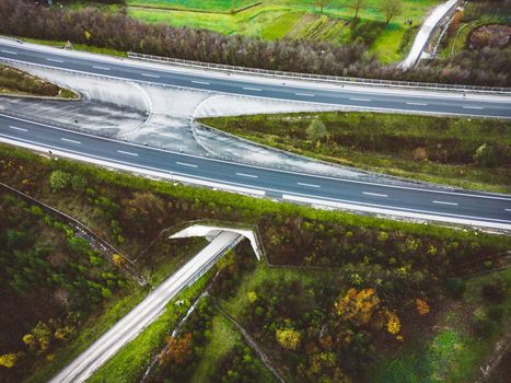 Drone shoot aerial view of a highway trough Slovenia. Green hills around it.