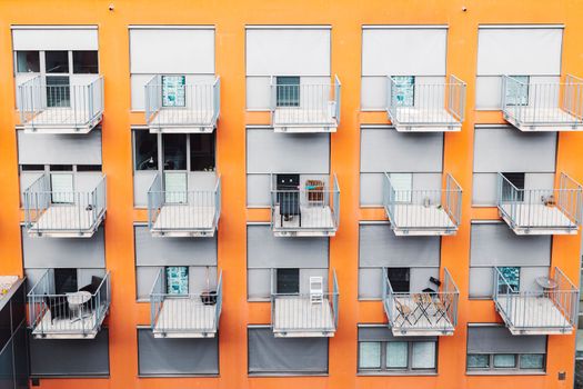 College dorm from outside, view of an orange building with grey balconies. A building where students come to live during their studies.