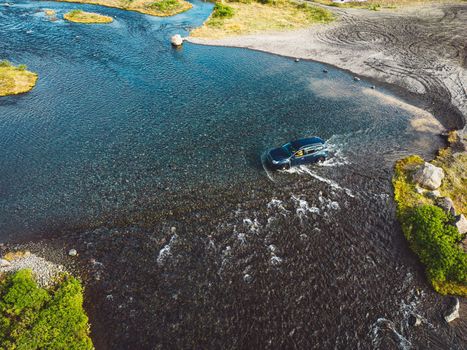 Car driving across the water somewhere in Iceland inland. Flooded roads in Iceland. Car driving trough water. Extreme conditions.