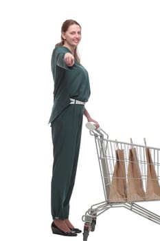 Side view of young woman with shopping cart looking at camera
