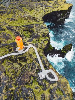 View of orange Svortuloft Lighthouse by the sea in West Iceland highlands, Snaefellsnes peninsula, View Point near Svortuloft Lighthouse. Spectacular black volcanic rocky ocean coast with cave arch and towers. High quality photo