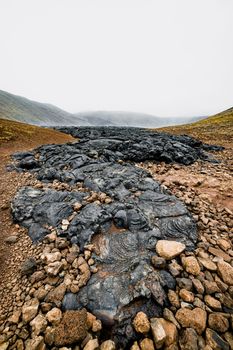 Geldingadalir active Volcano, errupting in 2021 - Fagradalsfjall and 2022 -Meradalir. Still hot lava rocks, steam comping up from the grounds. Dark grey, black volcanic rocks in Iceland. Dramatic view of lava rocks cold cloudy autumn day in Iceland.