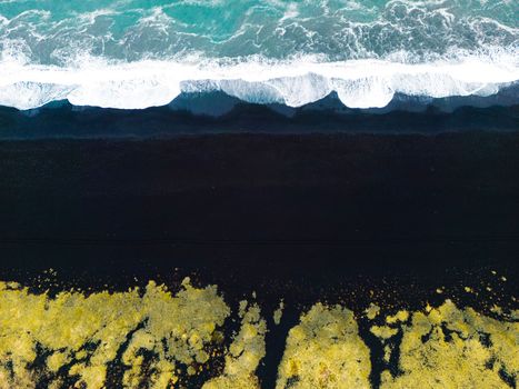 Volcanic Black Sand Beach with a view of Reynisdrangar. Waves crashing on the black sand beach. Vik, Iceland. High quality photo