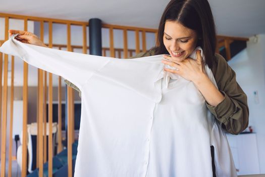 Young caucasian woman receiving a big box of her online orders. Woman opening the package, getting excited to see the stuff she bought. High quality photo