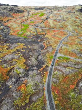 Icelandic highlands, F roads, river crossing. Remote dirt road somewhere in Iceland mainland, surrounded by vibrant green bushes and volcanic lands. A car driving alone on the gravel road.