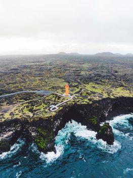 View of orange Svortuloft Lighthouse by the sea in West Iceland highlands, Snaefellsnes peninsula, View Point near Svortuloft Lighthouse. Spectacular black volcanic rocky ocean coast with cave arch and towers. High quality photo