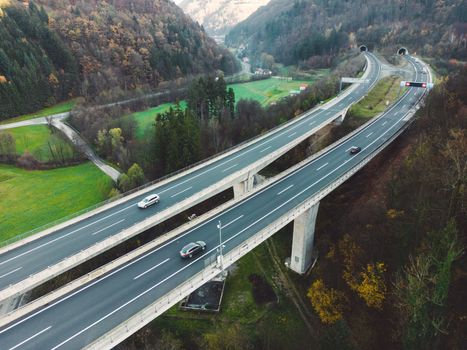 Drone shoot aerial view of a highway trough Slovenia. Green hills around it.