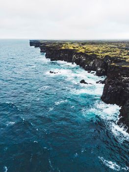 View of orange Svortuloft Lighthouse by the sea in West Iceland highlands, Snaefellsnes peninsula, View Point near Svortuloft Lighthouse. Spectacular black volcanic rocky ocean coast with cave arch and towers. High quality photo