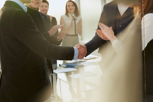 through the blinds. business partners shake hands . photo with copy-space.
