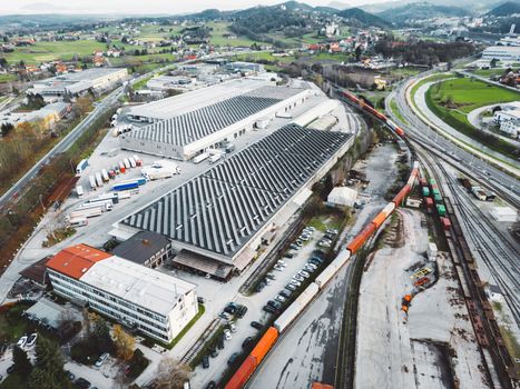 Aerial view of solar panels on industrial buildings. Drone point of view, flying over industrial area, with roof tops covered in solar panels.