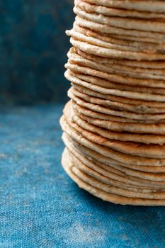 Flatbread lavash, chapati, naan, heap of tortilla on a blue background Homemade flatbread stacked