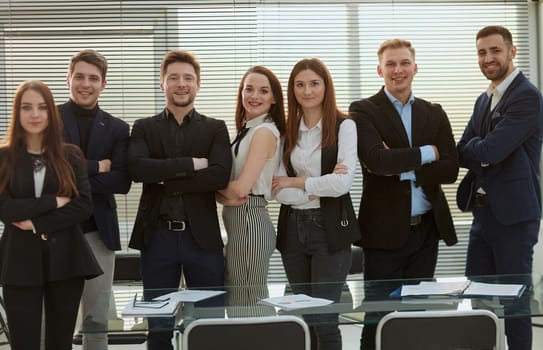 group of confident young employees standing in the office. concept of professionalism.