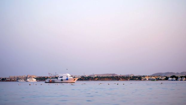 at sunset a small yacht is anchored in a sea bay. High quality photo