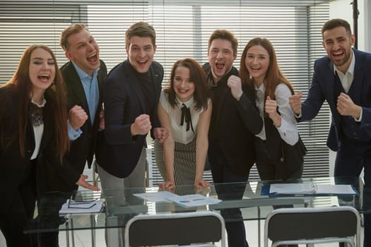 ambitious business team standing near the desktop. the concept of success.