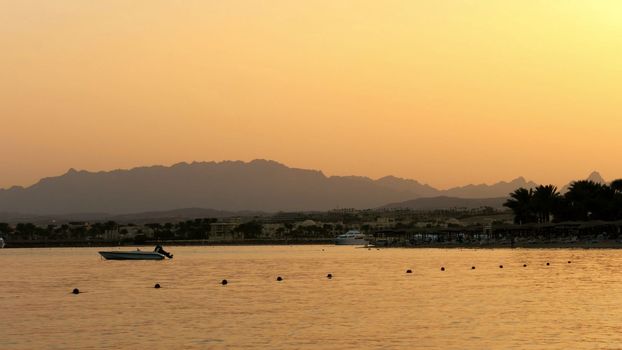  One of many quiet coves of the Red Sea, at sunset, at dusk. against the background of the outlines of mountains, palm trees. High quality photo