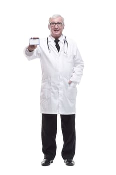 in full growth.qualified mature doctor showing his visiting card . isolated on a white background.