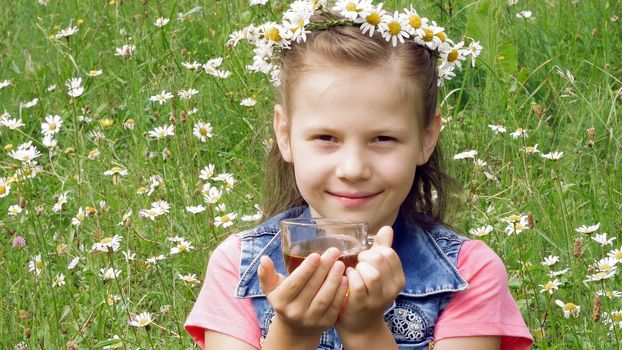 On a chamomile lawn, a sweet girl in a wreath of daisies, smiling, pressing her hands to her cheeks. High quality photo