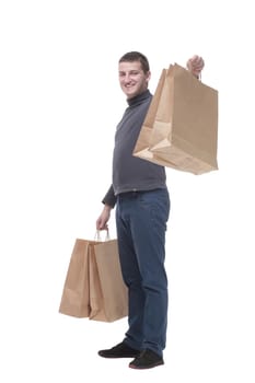 in full growth. casual young man with shopping bags. isolated on a white background.