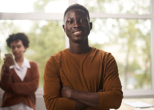 Portrait of happy African American small business owner posing with hands folded