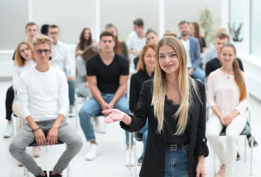 young woman standing in front of an audience in a conference room. business and education