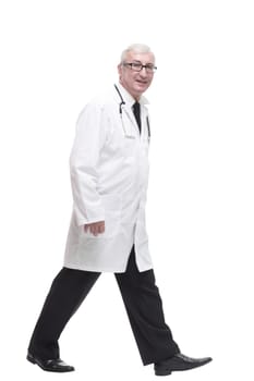 qualified mature doctor with stethoscope stepping forward. isolated on a white background.