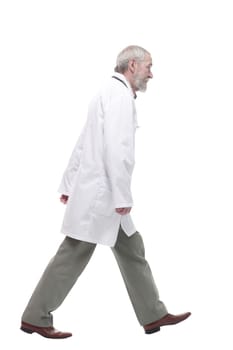 in full growth. elderly competent doctor striding forward. isolated on a white background.