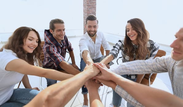 closeup. a group of employees with hands clasped together.the concept of teamwork,