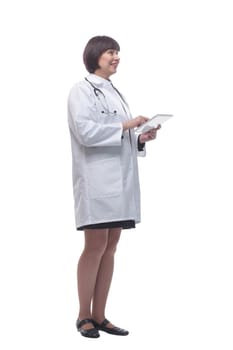 in full growth. female doctor using a digital tablet . isolated on a white background.