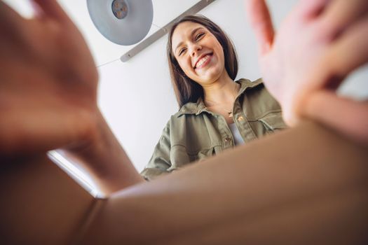 Young caucasian woman receiving a big box of her online orders. Woman opening the package, getting excited to see the stuff she bought. High quality photo