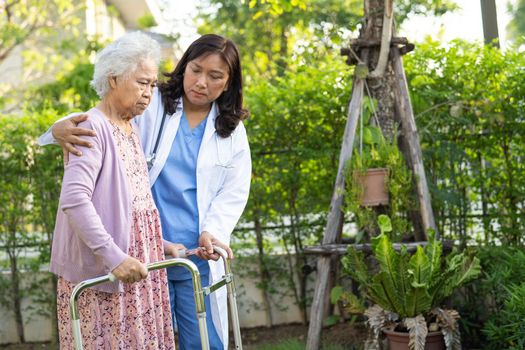 Doctor help and care Asian senior or elderly old lady woman use walker with strong health while walking at park in happy fresh holiday.