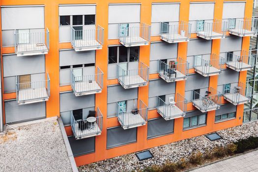 College dorm from outside, view of an orange building with grey balconies. A building where students come to live during their studies. 