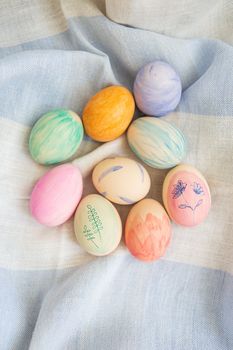 Painted bright and multi-colored Easter eggs on the background of a linen tablecloth, eggs painted with watercolors